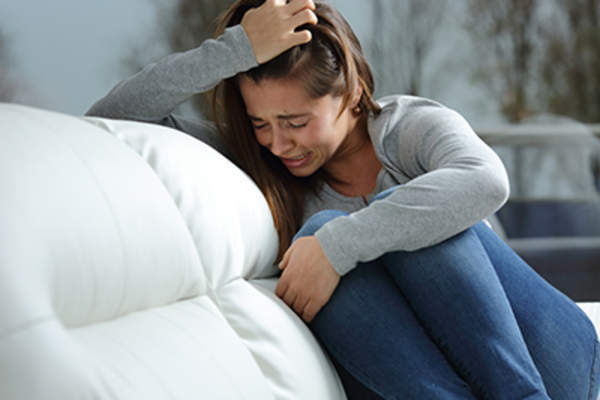 女人在沙发上哭泣。