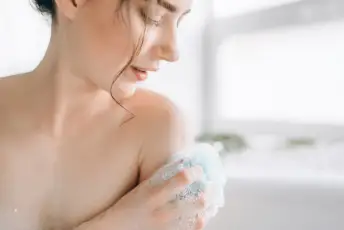 一个女人在淋浴时洗肩膀。