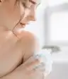 一个女人在淋浴时洗肩膀。