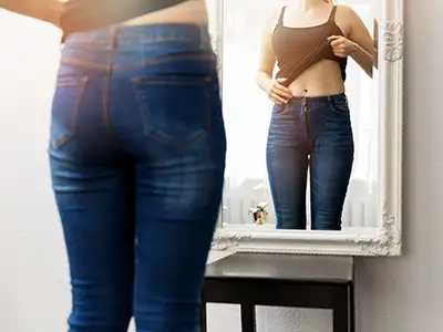 女人在镜子前检查自己的身体。