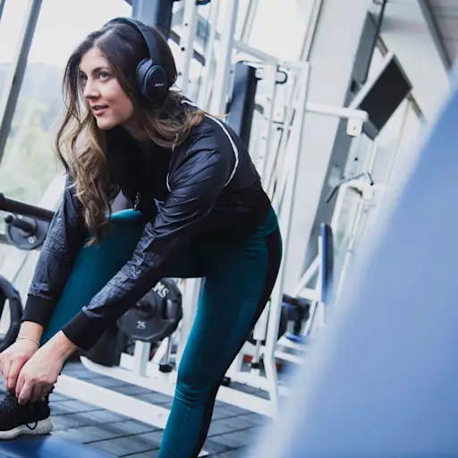 woman in gym tying shoe