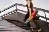 一个女人拿着瑜伽垫走楼梯