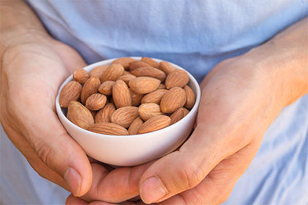 男子拿着杏仁一碗。