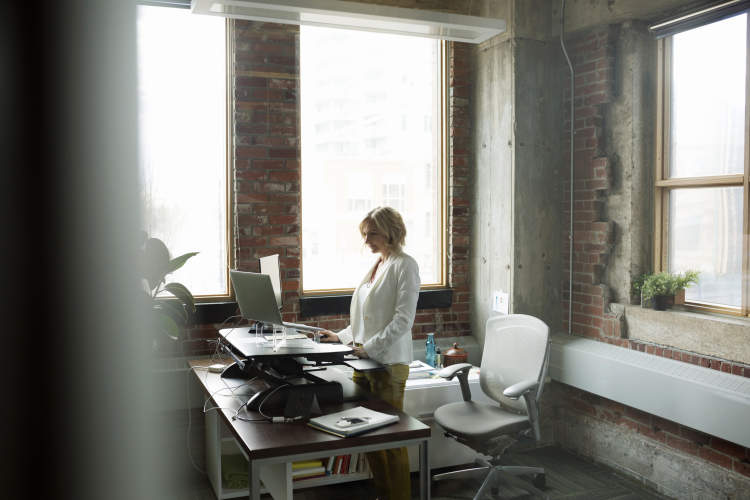 在女人站在办公桌前工作。