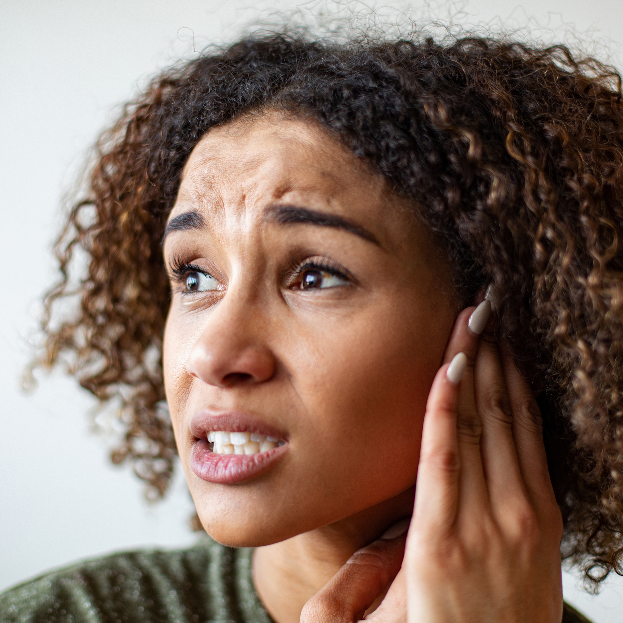 女性会因耳后肿块而感到疼痛。