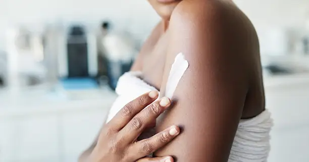 Woman applying moisturizer