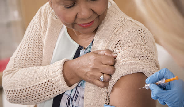 护士在门诊给老年病人接种流感疫苗