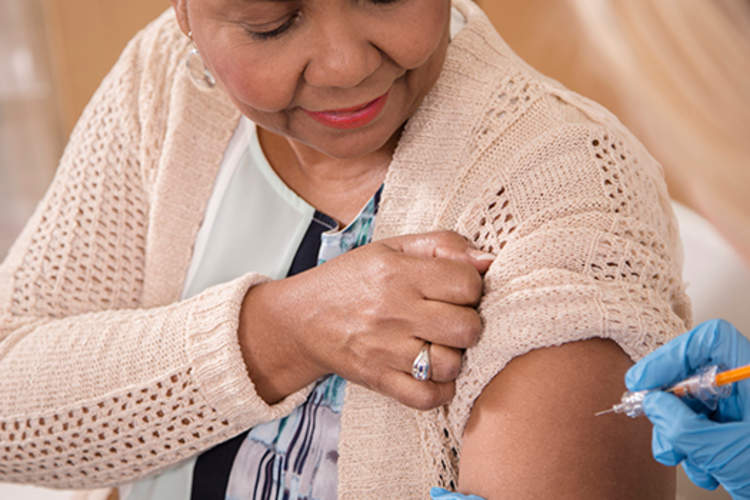 护士给流感疫苗在临床资深成年患者
