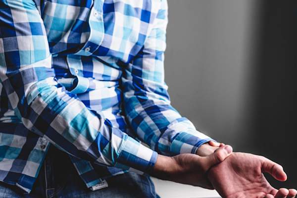 疼痛年轻男子拿着手腕