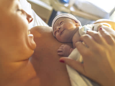 母亲抱着新生婴儿分娩后。