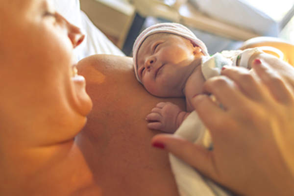 母亲抱着新生婴儿分娩后。