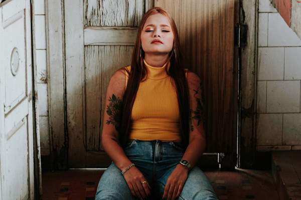 女子坐在地板上闭眼