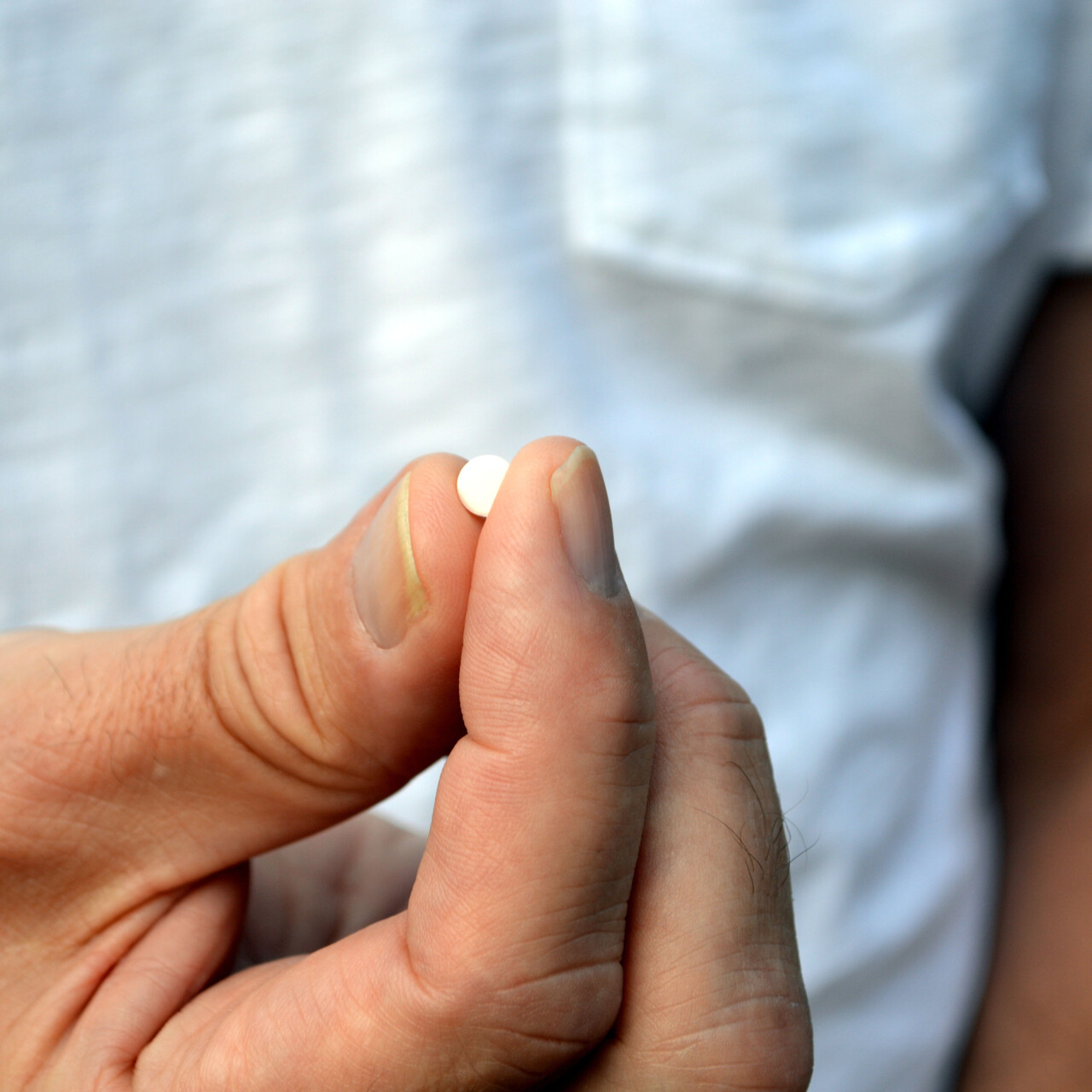 男人拿着白色药片。