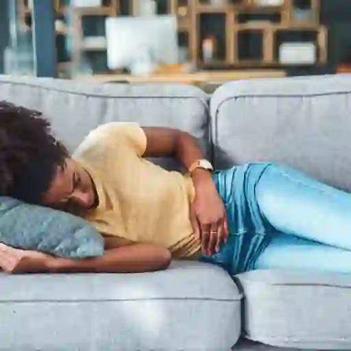 一个女人躺在沙发上摸着自己的肚子