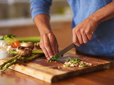 男子切割砧板上的蔬菜。
