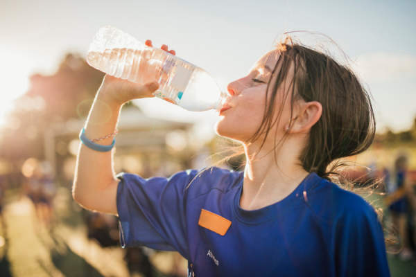 女孩在足球训练时用水瓶喝水