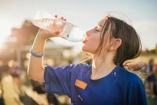 女孩在足球训练时从水瓶里喝水