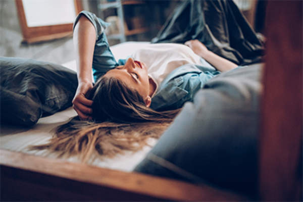 不舒服的年轻女子躺在她的床上。
