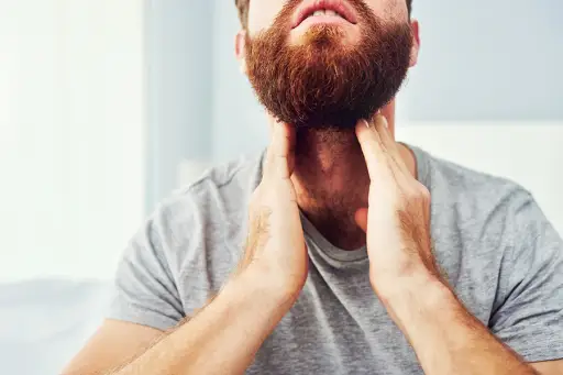 Man checking his neck for swollen lymph nodes