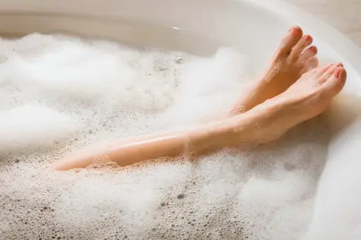 女人的腿，而她在泡泡浴中放松。
