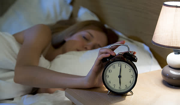 女人睡在床上，动人的闹钟。