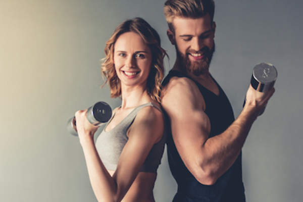 爱好运动的男人和女人背靠背冰壶哑铃。