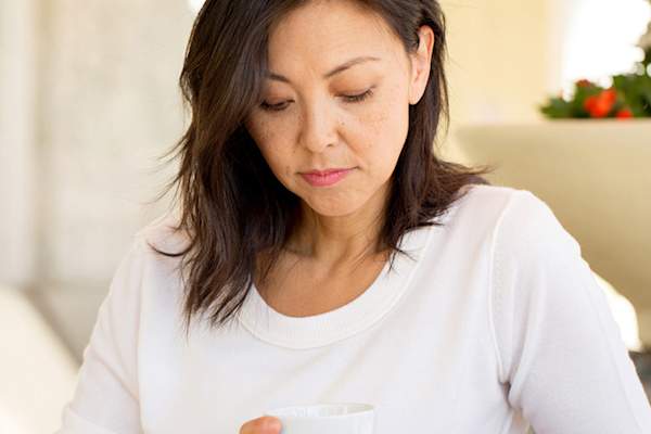 痛苦的女人低头看着她的咖啡杯。