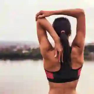 fit woman stretching shoulder
