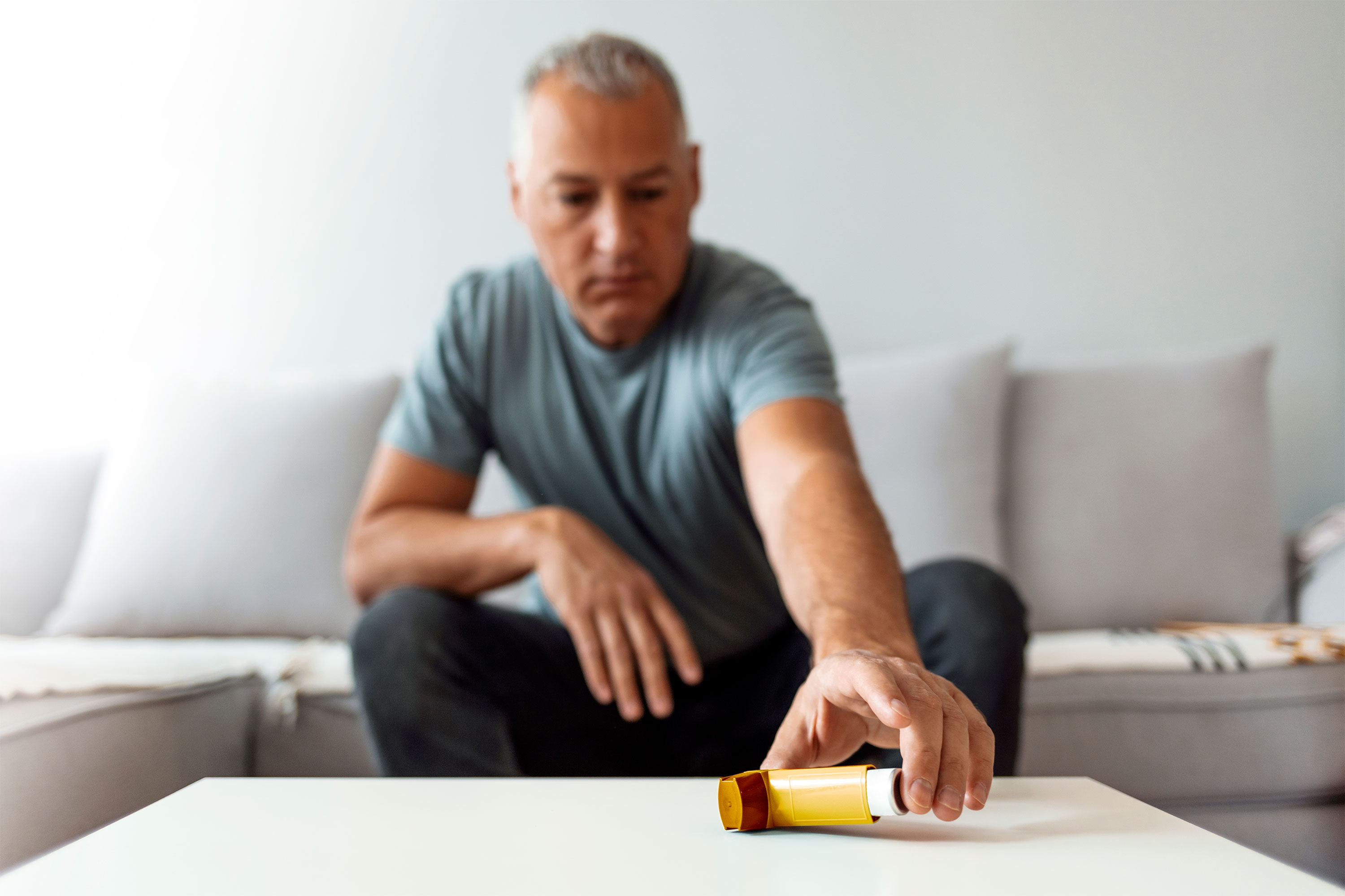 一个男人向他的吸入器在家里