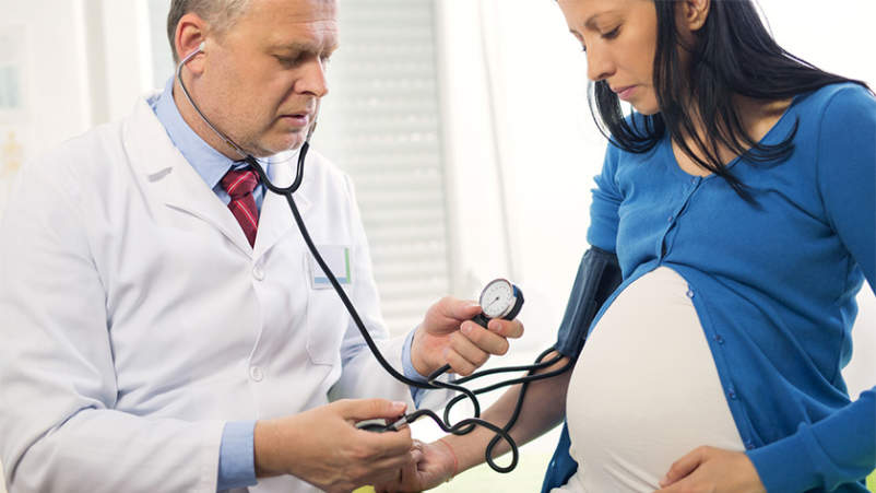 医生测量孕妇的血压。