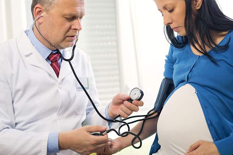 医生测量孕妇的血压。