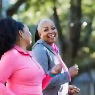 Two senior women power walking and talking