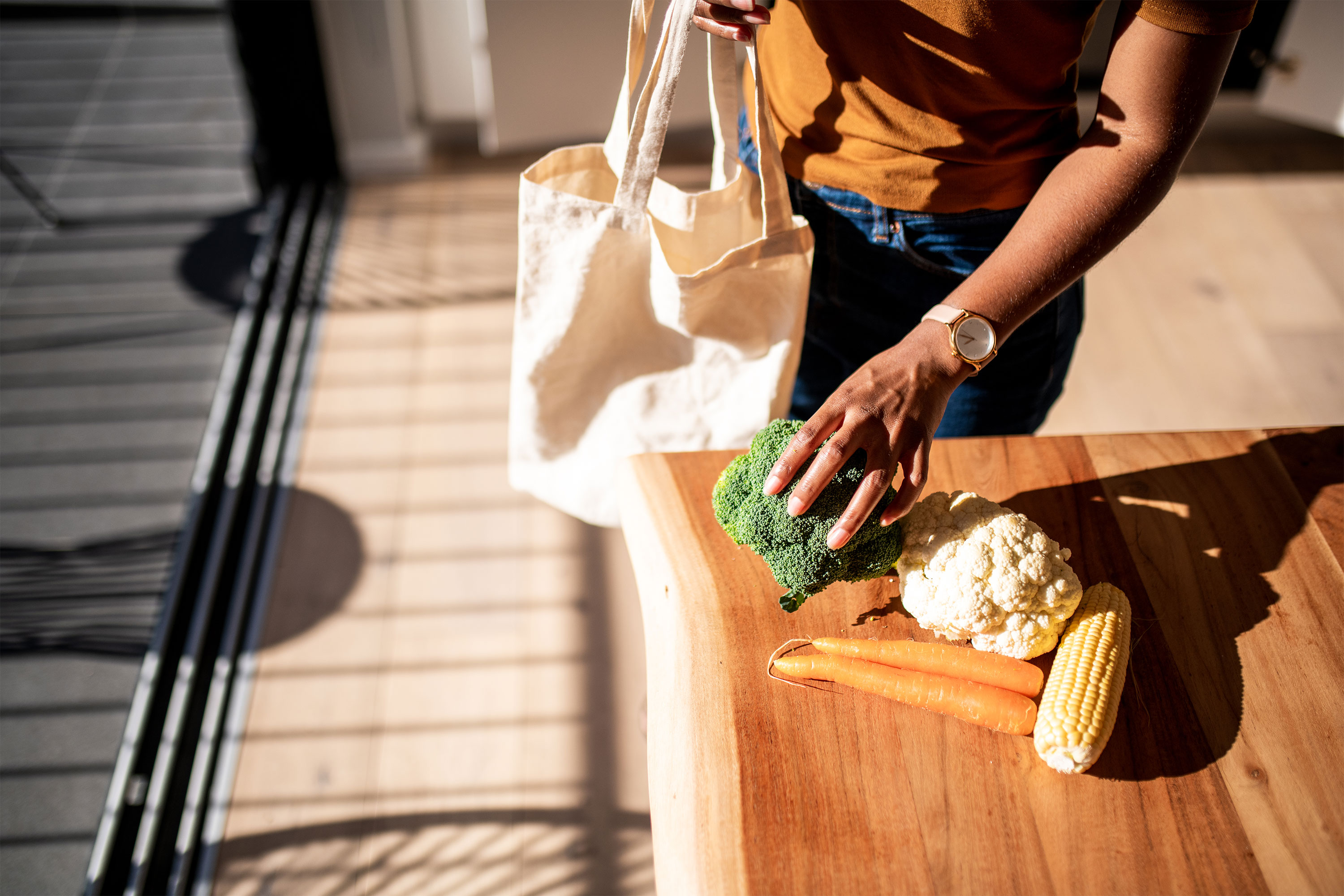 一位妇女在厨房里打开农产品的包装