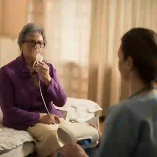 高级的女人在家与氧气治疗。