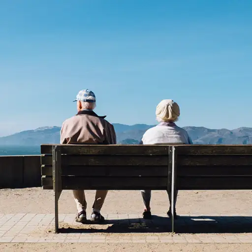 一对老夫妇坐在长凳上望着远方