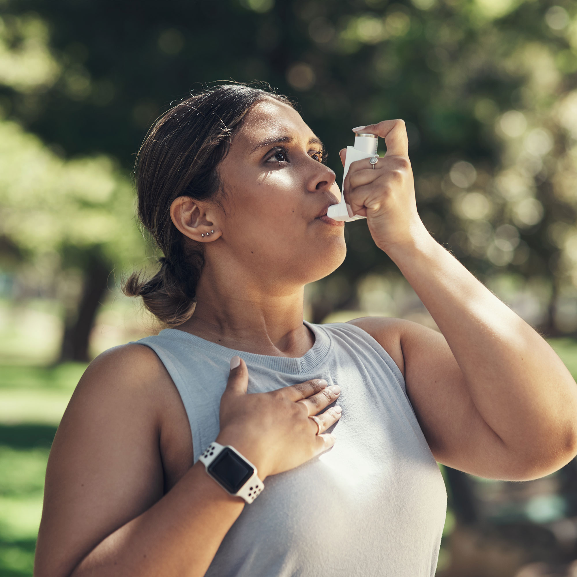 一个女人在外面用她的吸入器