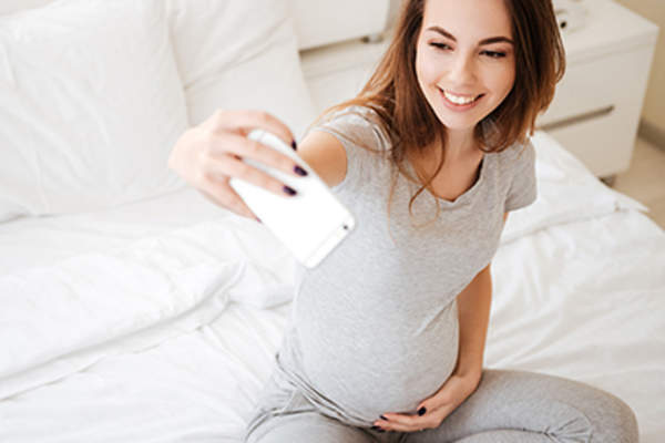 年轻的孕妇在自拍。