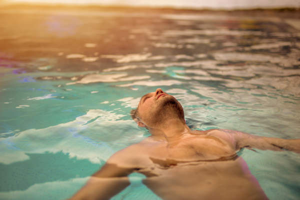 一个男人在游泳池里放松。