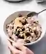 有人在吃一碗燕麦粥,里面有蓝莓和香蕉