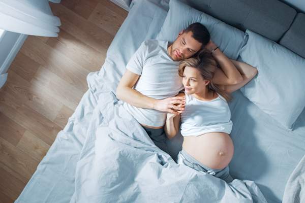 夫妻在床上,男人睡觉,醒着的女人