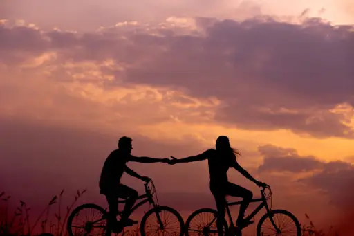 情侣在自行车上抚摸双手