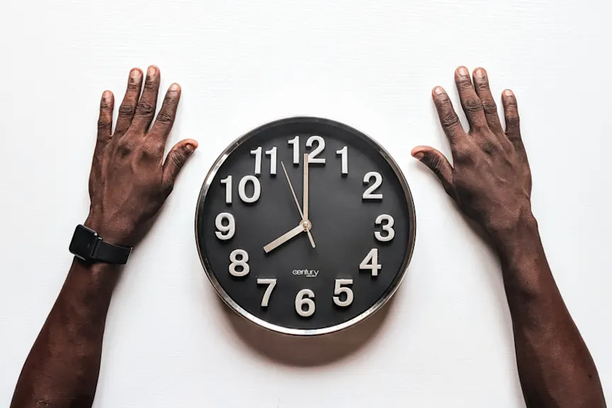 arms on table surrounding clock