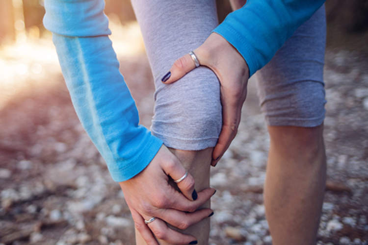 对线索控股伤害膝盖的女人慢跑。