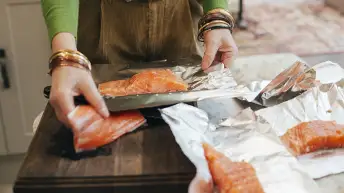 用箔纸包鲑鱼的女人。