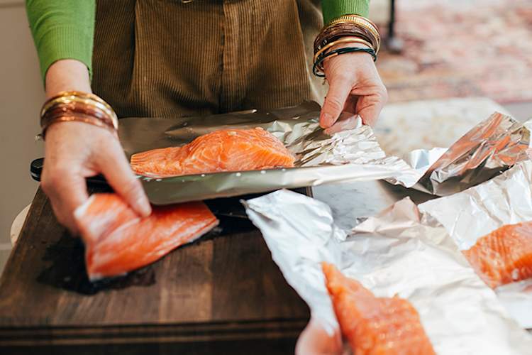 女人包裹鲑鱼箔。