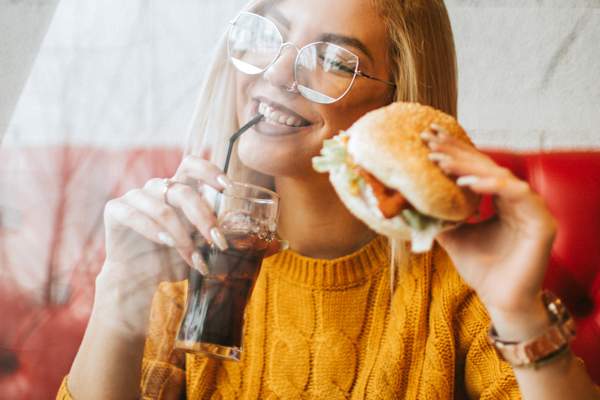 年轻的女人吃快餐