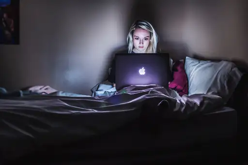 睡眠剥夺的女人在笔记本电脑上熬夜