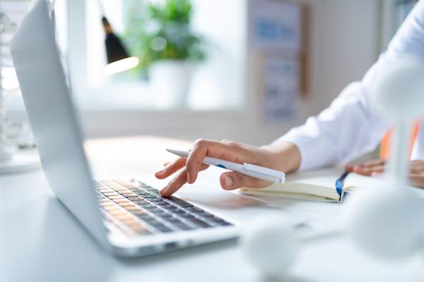 女化学家拿着白色的笔使用笔记本电脑