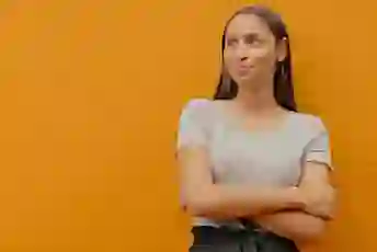 女人交叉着双臂站在那里,看着别处沉思