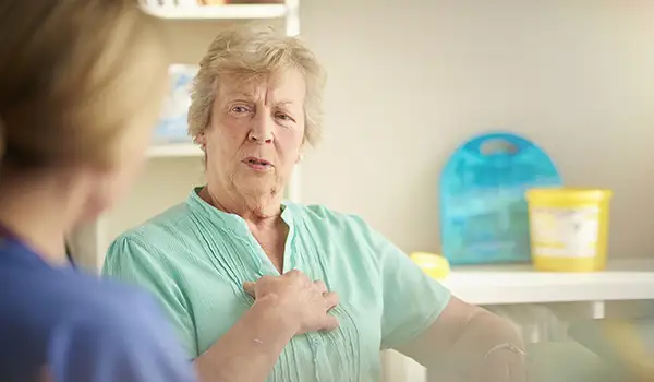 一位年长的女士正在和医生讨论胸痛。